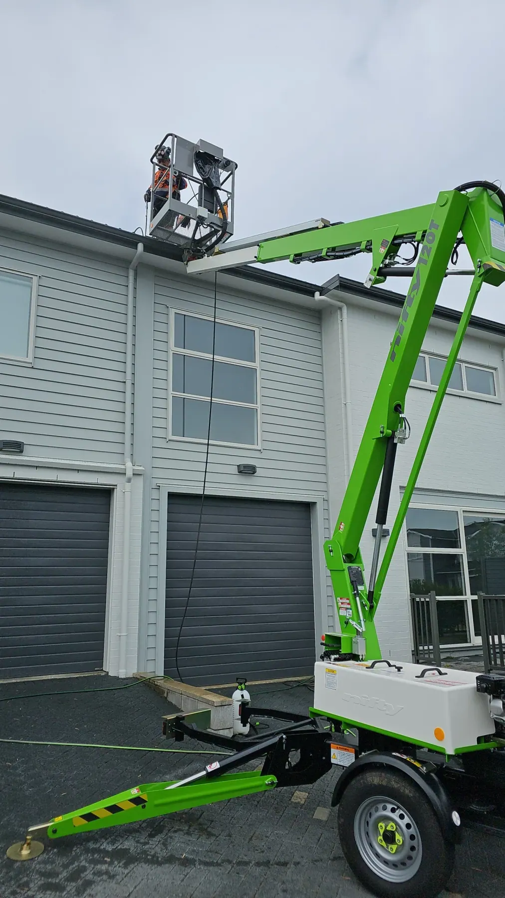 Elevated work platform reaching a commercial building exterior