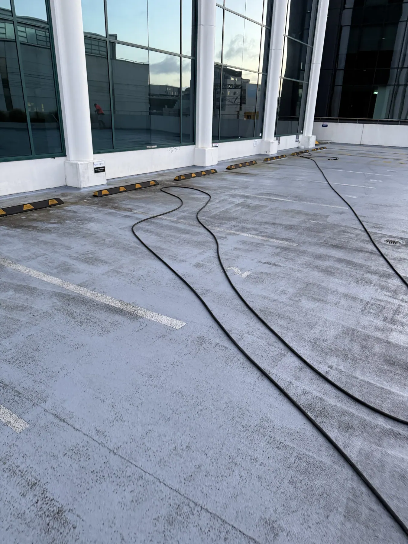 Concrete hard surface being waterblasted clean